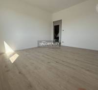 An empty room in a family house with wooden flooring and white walls.
