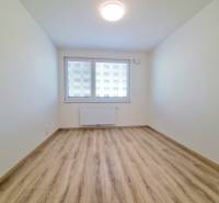 A room in a 3-room apartment with laminate flooring and a window with a view.