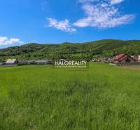 Greenery and panorama in Udiča, plots - housing with houses and wooded hills in the background.