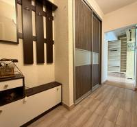 Hallway of a 2-room apartment with a coat rack and an antique telephone.