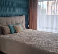A bedroom with a bed and decorative pillows in a 2-room apartment.
