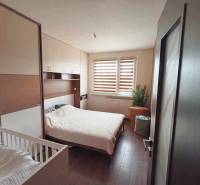 Bedroom in a 3-room apartment with a bed, a baby crib, and a wardrobe.