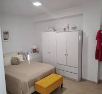 A bright bedroom in a 2-room apartment with a wardrobe, bed, and colorful furniture.