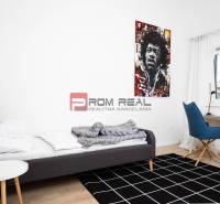 Bedroom in a 3-room apartment with a bed, an armchair, and a picture on the wall.