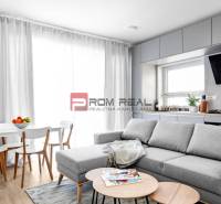 Living room with a kitchen in a 3-room apartment, light sofa and dining table.