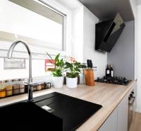 A kitchen in a 3-room apartment with a built-in hob and plants on the windowsill.