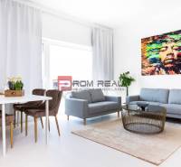 A bright living space in a 3-room apartment with a sofa, dining table, and abstract art.