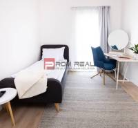A simple room in a 3-room apartment with a bed, desk, and decorations.