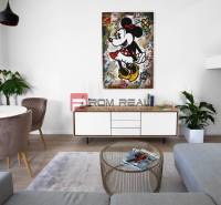 Living room with a colorful painting, comfortable seating, and a table in a three-room apartment.