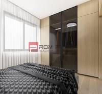 Bedroom in a 2-room apartment with a cabinet and a large window, light curtains.