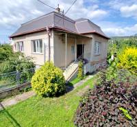 A family house in Veľký Šariš with a garden and driveway, surrounded by greenery.