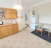 A kitchen in a family house with a wooden cabinet, table, and refrigerator.