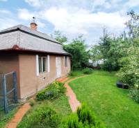 A family house in the town of Veľký Šariš surrounded by a garden and greenery.