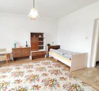 A room in a family house with antique furniture, a carpet, and a bed.