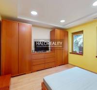 Yellow bedroom with a wooden wardrobe and windows in a family house.