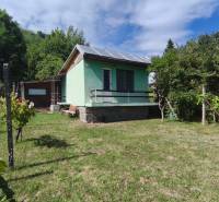 A cottage on Strhárska Street in Modrý Kameň surrounded by green lawn and trees.