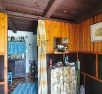 The interior of the cabin with wooden paneling, curtains, and rustic furniture creates a cozy atmosphere.