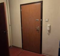Entrance door to a 3-room apartment with red linoleum and white walls.
