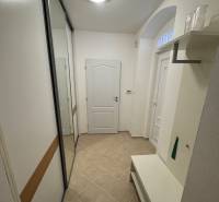 A bright hallway with tiles, a built-in wardrobe, and a bench in a 2-room apartment.