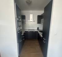 A kitchen in a 3-room apartment with dark cabinets and built-in appliances.