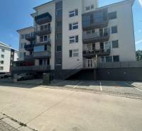 Five-story apartment building with a staircase and parking lot on Slavomírova Street in Slovenský Grob.