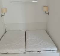 A double bed with wall lamps in a two-room apartment.