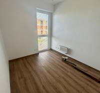 An empty room with laminate flooring and a large window in a 3-room apartment.