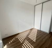 An empty room in a 3-room apartment with a wooden floor and a built-in wardrobe.
