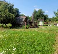 A country house surrounded by greenery with a dirt road on A.H. Škultétyho Street.