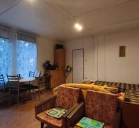The cabin features a wooden staircase, a dining table, and older furniture.