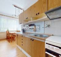 A kitchen with a dining table and appliances in a 4-room apartment.