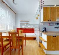 A kitchen in a 4-room apartment with wooden furniture and a dining table.
