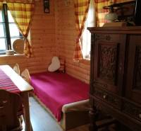 The interior of a log cabin with solid furniture, wooden walls, and colorful curtains in a family house.