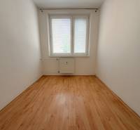 An empty room with a window and a radiator, wooden floor, 3-room apartment.