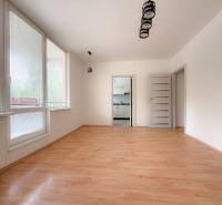 A spacious room in a 3-room apartment with wooden flooring and large windows.