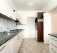 Kitchen of a 3-room apartment with a tiled wall, double sink, and built-in oven.