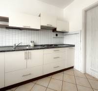 A kitchen unit with white doors and a black countertop in a 3-room apartment.