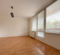 A spacious room with large windows and laminate flooring in a 3-room apartment.