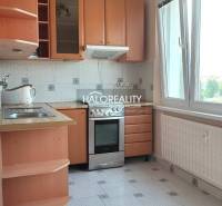 A kitchen in a 4-room apartment with wooden cabinets and a large window.