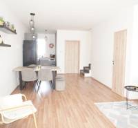 Living room in a family house with wooden flooring and light furniture.