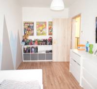 Children's room with figurines, comics on the wall, and white furniture in a family house.