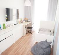 A children's room in a family house with white furniture and wooden flooring.