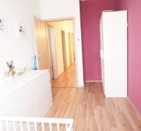 A children's room in a family house with a wooden floor and a purple wall.