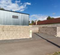 A sheet metal building and a block wall by the road at the Recreational Grounds in Záhorce, Selešťany.