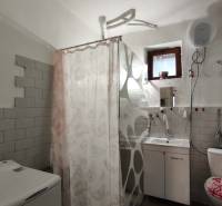 Bathroom in a family house with a bathtub, toilet, and washing machine.