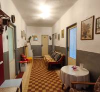 Hallway in a family house with a sofa, pictures on the walls, and a table with decoration.