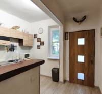 A kitchen in a family house with cabinets, a stove, a sink, and a window.