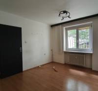 A room with a wooden floor, a window, and a radiator in an office.