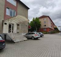 Office building on SNP Street in Veľký Krtíš, parking and entrance stairs.