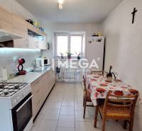 A kitchen in a 2-room apartment with appliances, a dining table, and a bright interior.
